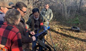 Professor Wang discusses mapping tools with students and community volunteers outdoors: Link to: Historic Preservation Priojects