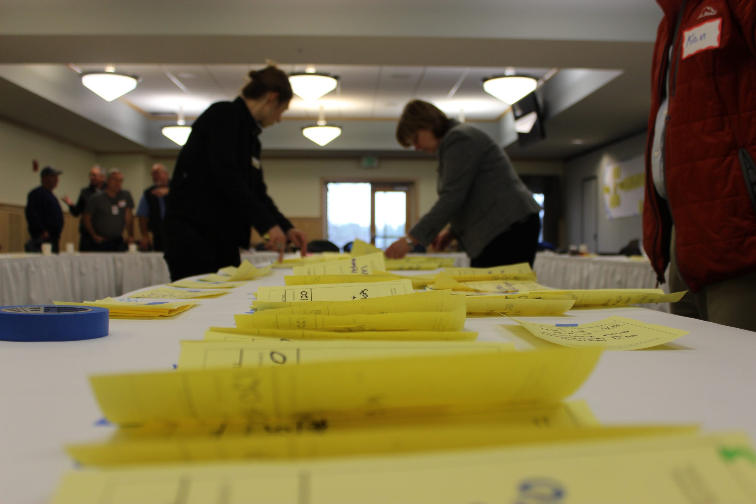 Step sheets on a table with people working