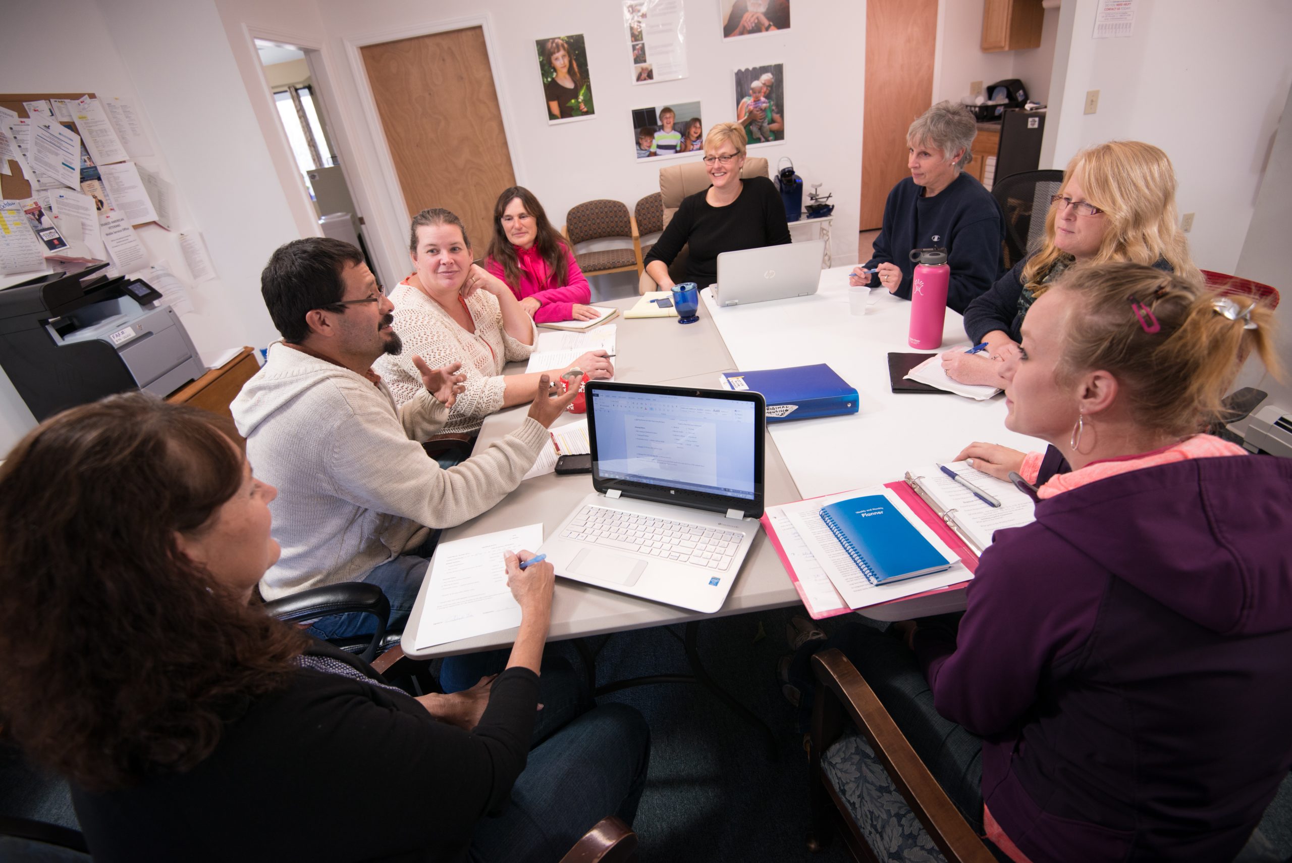 Several people sitting around a table having a discussion.