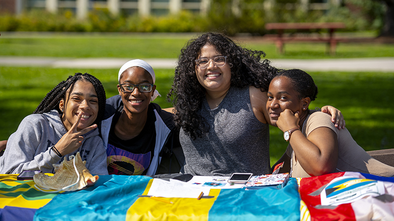 Group of students sitting at a table outside.
