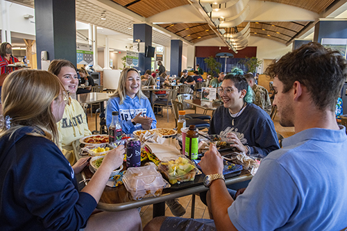 Students around a table eating a meal in student union