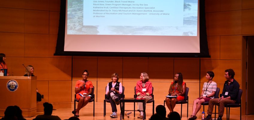 Industry professionals sit on stage during panel discussion
