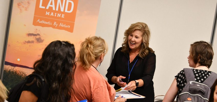 Conference exhibitor talking with conference attendees