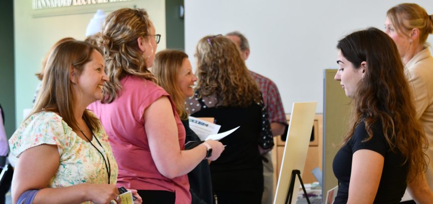 Conference exhibitor talking with conference attendee