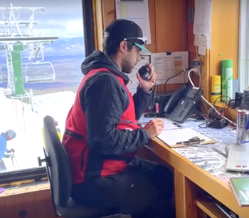 Student sitting at ski patrol desk on a mountain