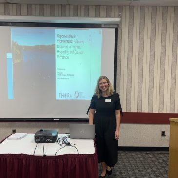 THOR program manager stands in front of presentation in conference room