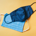 Photograph of layered face coverings: one surgical mask and one cloth mask.