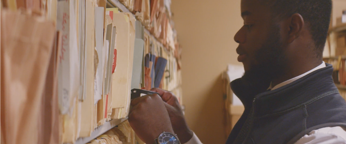 Joshua Mutshaila choosing a folder from a wall of files