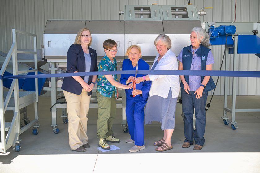 Ribbon cutting ceremony featuring five individuals standing side by side (from left to right): Jeannie Tapley, Executive Director of the Maine Potato Board; Salem Ermish, University of Maine Ph.D. student; Governor Janet Mills; University of Maine President Joan Ferrini-Mundy; and Diane Rowland, Director of the Maine Agricultural and Forest Experiment Station. Photo courtesy of the University of Maine.
