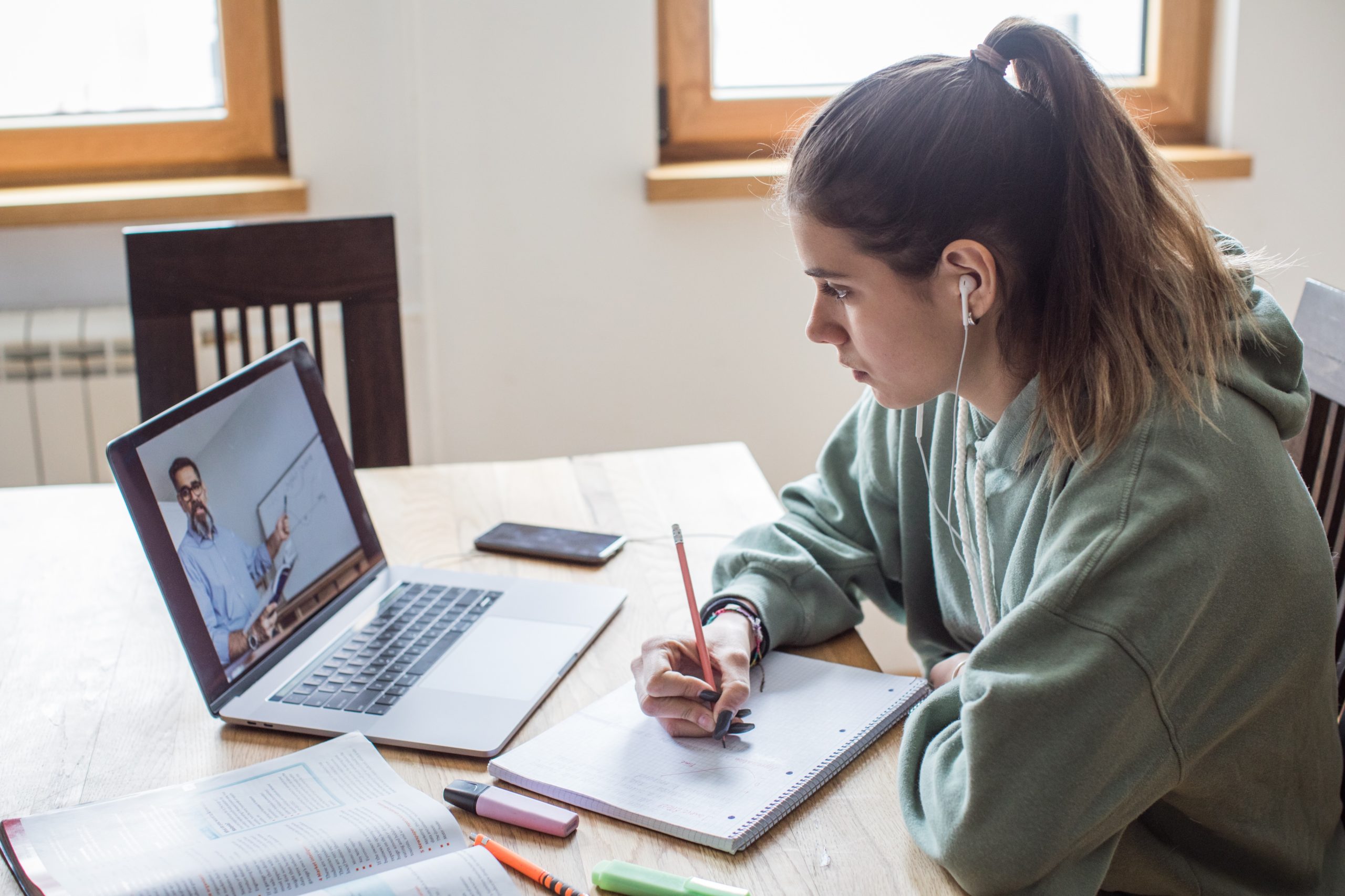A UMaine Online student taking notes during an online class